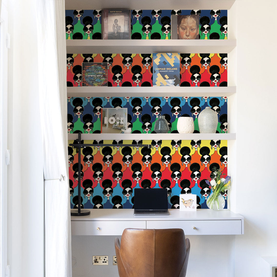 White shelves and a white desk in front of Tempaper's Rainbow Stace Peel And Stick Wallpaper By Alice + Olivia.