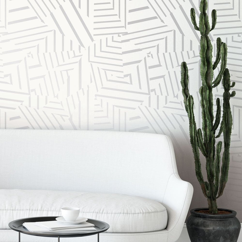White Dazzle removable wallpaper from Tempaper on the wall of a living room with a white couch and a tall floor cactus.