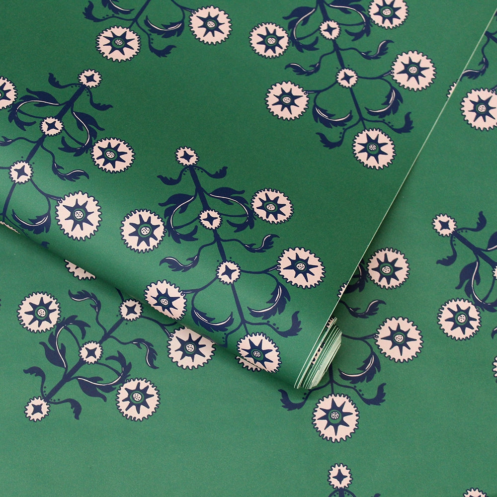 A slightly unraveled roll of Block Print Floral WALLPAPER in green.