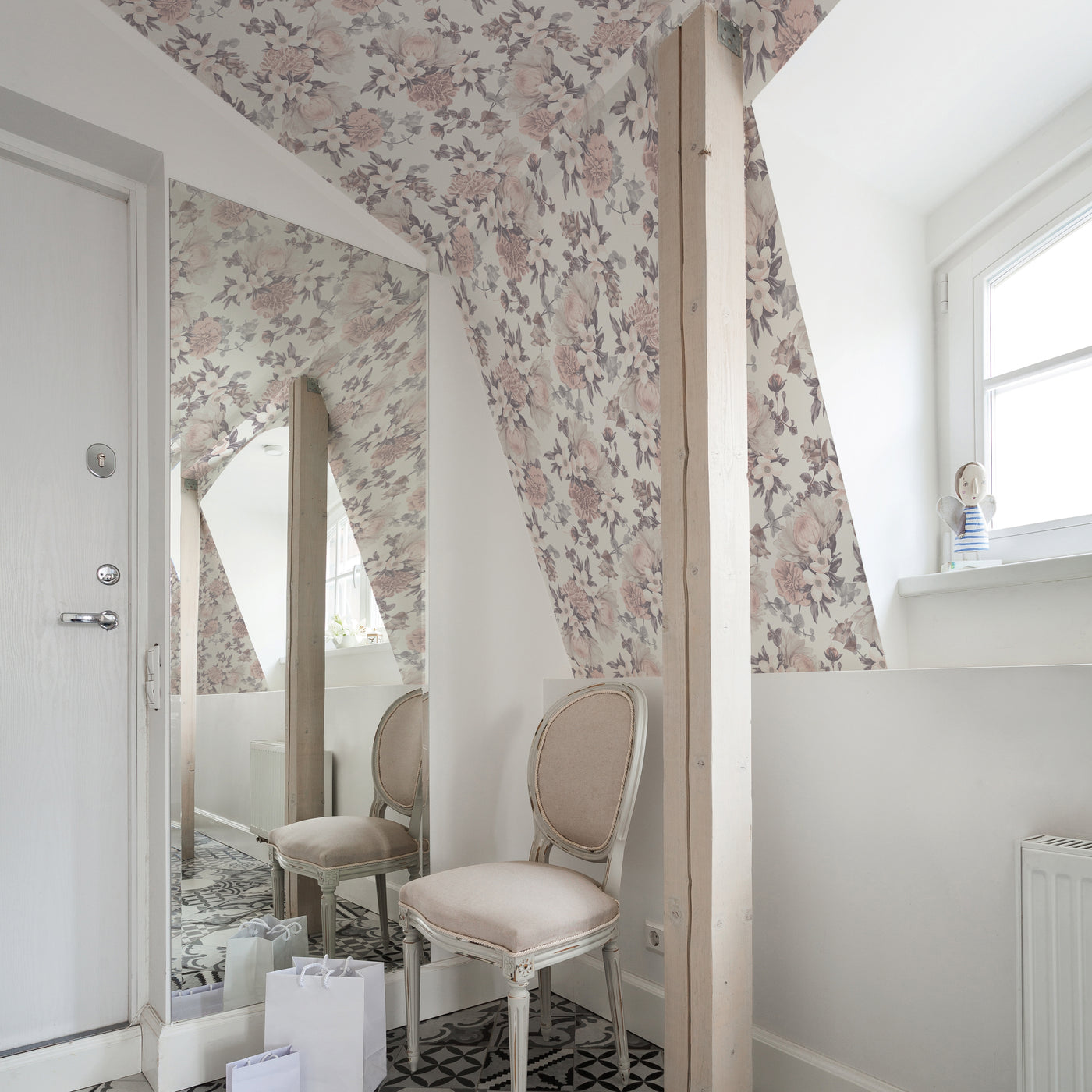 Botanical WALLPAPER in mauve pink displayed in a kid's room behind a chair.