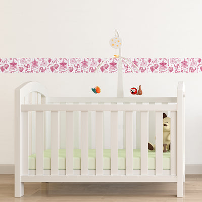 Tempaper's Carnival peel and stick wallpaper in pink shown behind a crib.