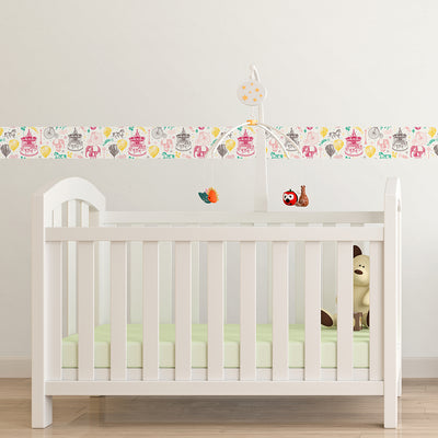 Tempaper's Carnival peel and stick wallpaper in rainbow shown behind a crib.