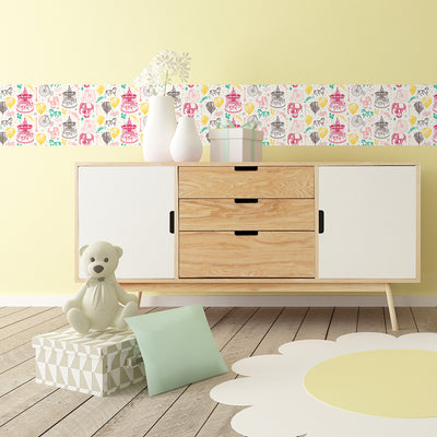Tempaper's Carnival peel and stick wallpaper in rainbow shown behind a dresser.