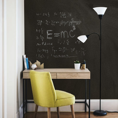 A desk area with scientific formulas written on the wall using Tempaper's chalkboard wallpaper.