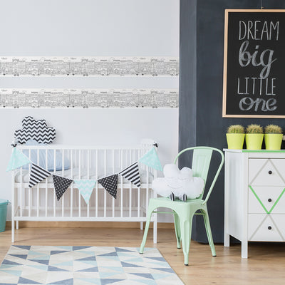 Tempaper's City Border Peel And Stick Wallpaper shown in a kids bedroom behind a crib.