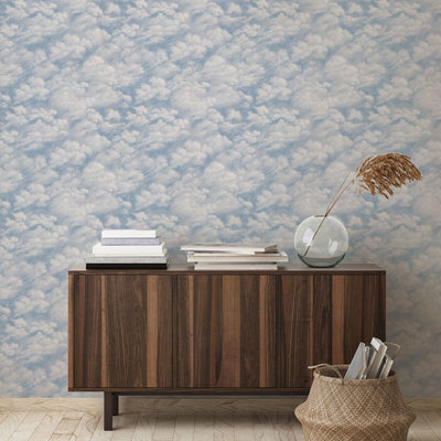 Tempaper's Clouds Peel And Stick Wall Mural in light blue shown behind a sideboard.