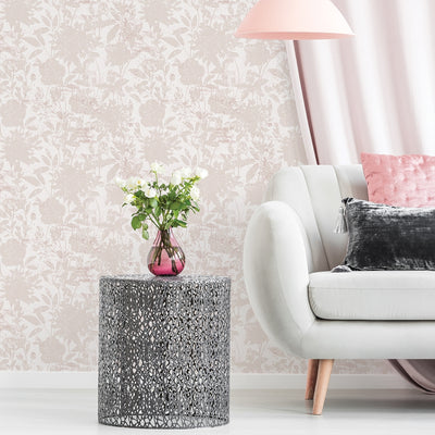Tempaper's Garden Floral Peel And Stick Wallpaper shown behind a couch and end table with a plant on top.