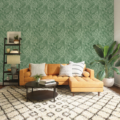 Tempaper's green grove Canvas Palm peel and stick wallpaper shown behind a couch.