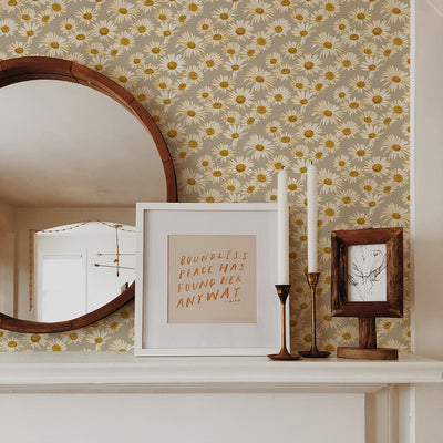 Tempaper's Daisies Peel And Stick Wallpaper By Novogratz shown behind a mirror and picture frame.