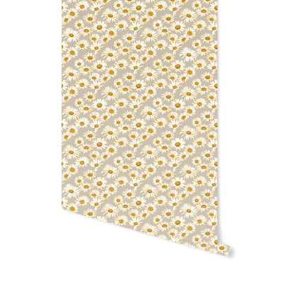A roll of Daisies floral peel-and-stick wallpaper from Tempaper rolling down a white wall.