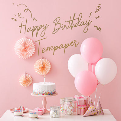 An up close view of Tempaper's Custom Happy Birthday Wall Decal with "Happy Birthday Tempaper" as an example shown above a cake and balloons.