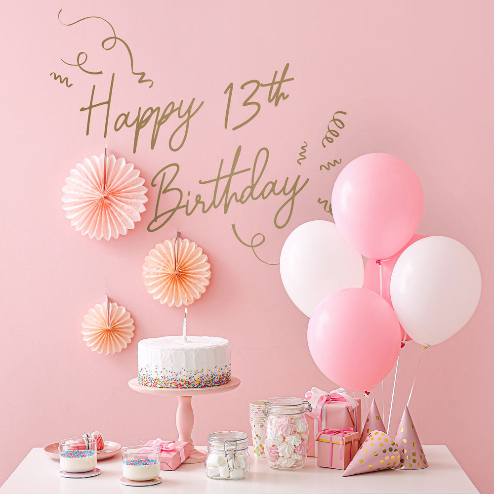 An up close view of Tempaper's Custom Happy Birthday Wall Decal with "Happy 13th Birthday" as an example shown above a cake and balloons.