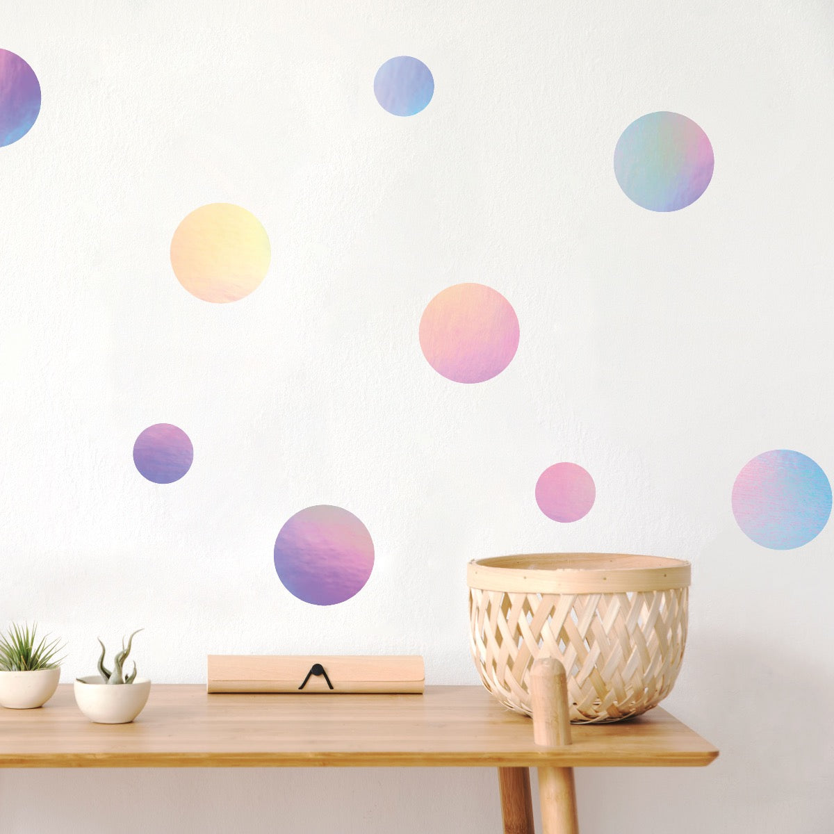 A side table with a wall that was decorated using holographic Dots wall decals from Tempaper.