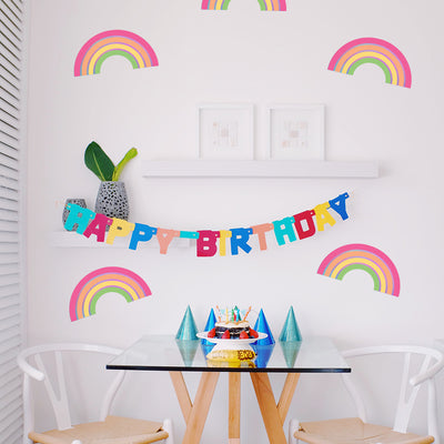 A seating area decorated for a birthday celebration with Rainbow wall decals from Tempaper on the wall.