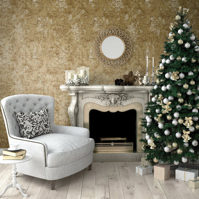 Tempaper's Distressed Gold Leaf Peel And Stick Wallpaper in metallic gold shown behind a chair, tree, and fireplace.#color_gold-leaf