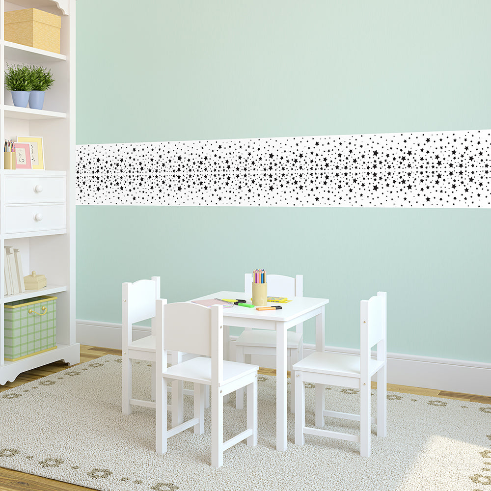 Strips of Tempaper's Falling Stars Border Peel And Stick Wallpaper in black and white shown above a table and chairs.