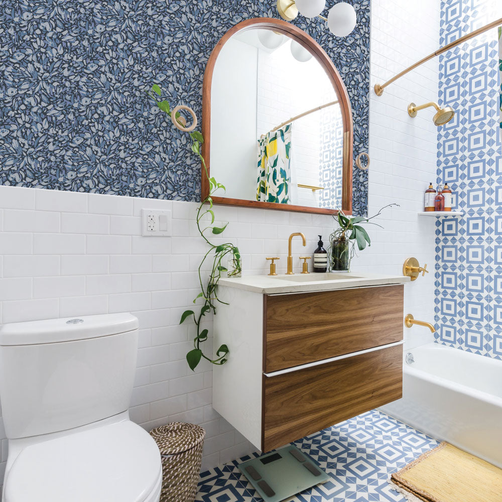 Tempaper's Flamboyan Peel And Stick Wallpaper By She She shown in a bathroom behind a toilet, sink, and mirror.