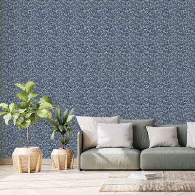Tempaper's Flamboyan Peel And Stick Wallpaper By She She shown behind plants and a couch.