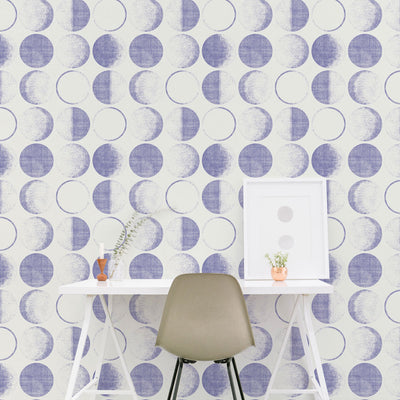 A white desk and green chair with Tempaper's Moons Removable Wallpaper in a periwinkle colorway.