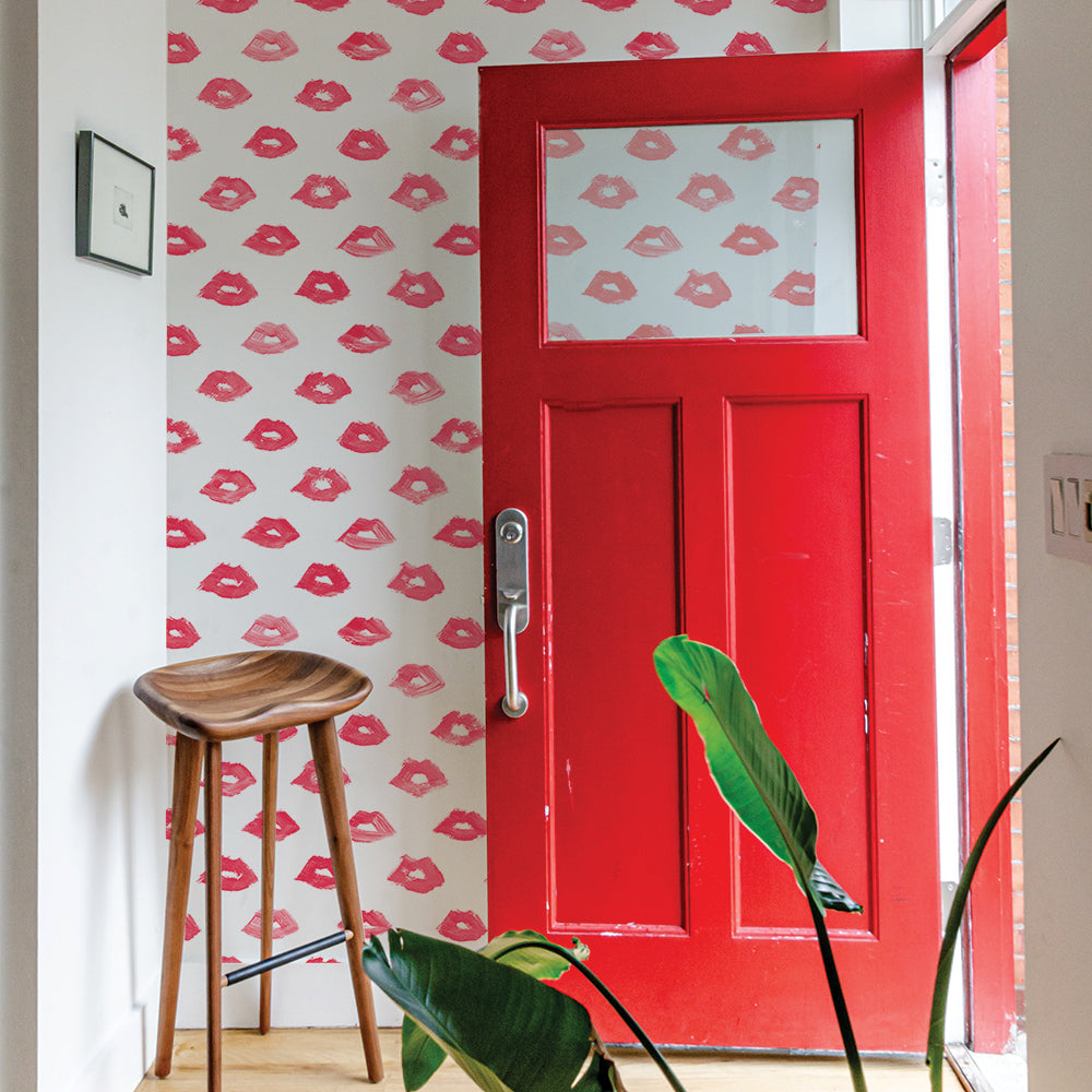 Painted Lips Removable Wallpaper - A red door and wood stool in an entryway featuring Painted Lips Peel And Stick Wallpaper by Novogratz | Tempaper