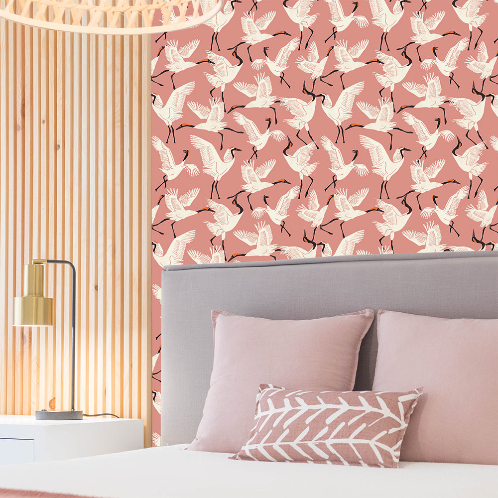 Tempaper's Family of Cranes Peel And Stick Wallpaper By Novogratz shown in a bedroom above a bed.