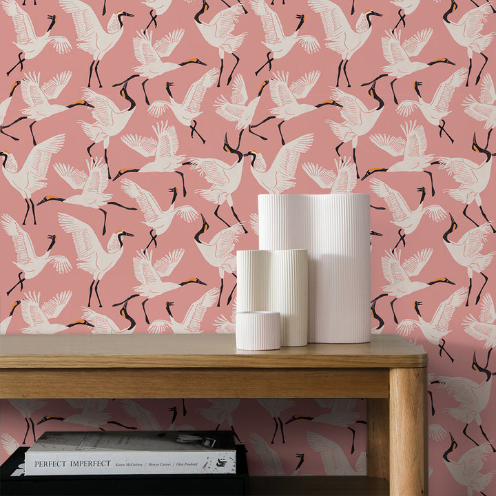 Tempaper's Family of Cranes Peel And Stick Wallpaper By Novogratz shown above a desk. #color_dusty-rose