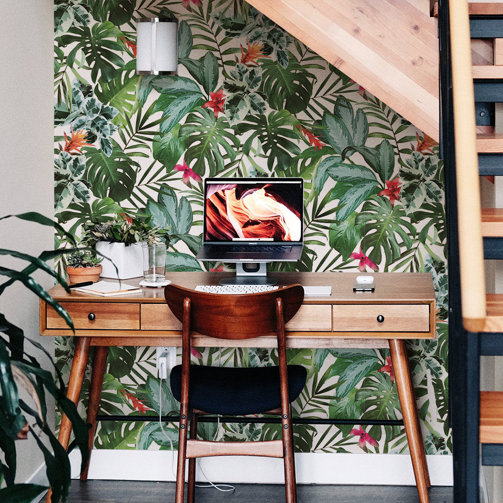 A desk nook at the base of the stairs with Rainforest removable wallpaper from Tempaper accenting the wall behind the desk.