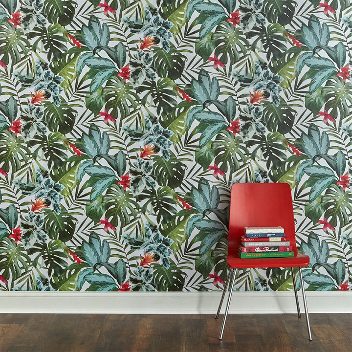 A wall with Rainforest removable wallpaper from Tempaper and a red chair with a stack of books on it.