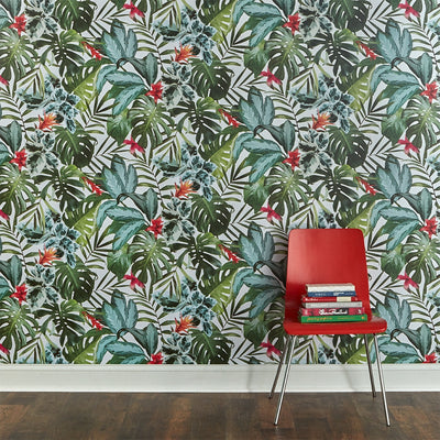 A wall with Rainforest removable wallpaper from Tempaper and a red chair with a stack of books on it.