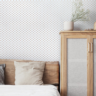 A bedroom with a wood headboard and dresser in front of Tempaper's Sunbeam Peel And Stick Wallpaper.