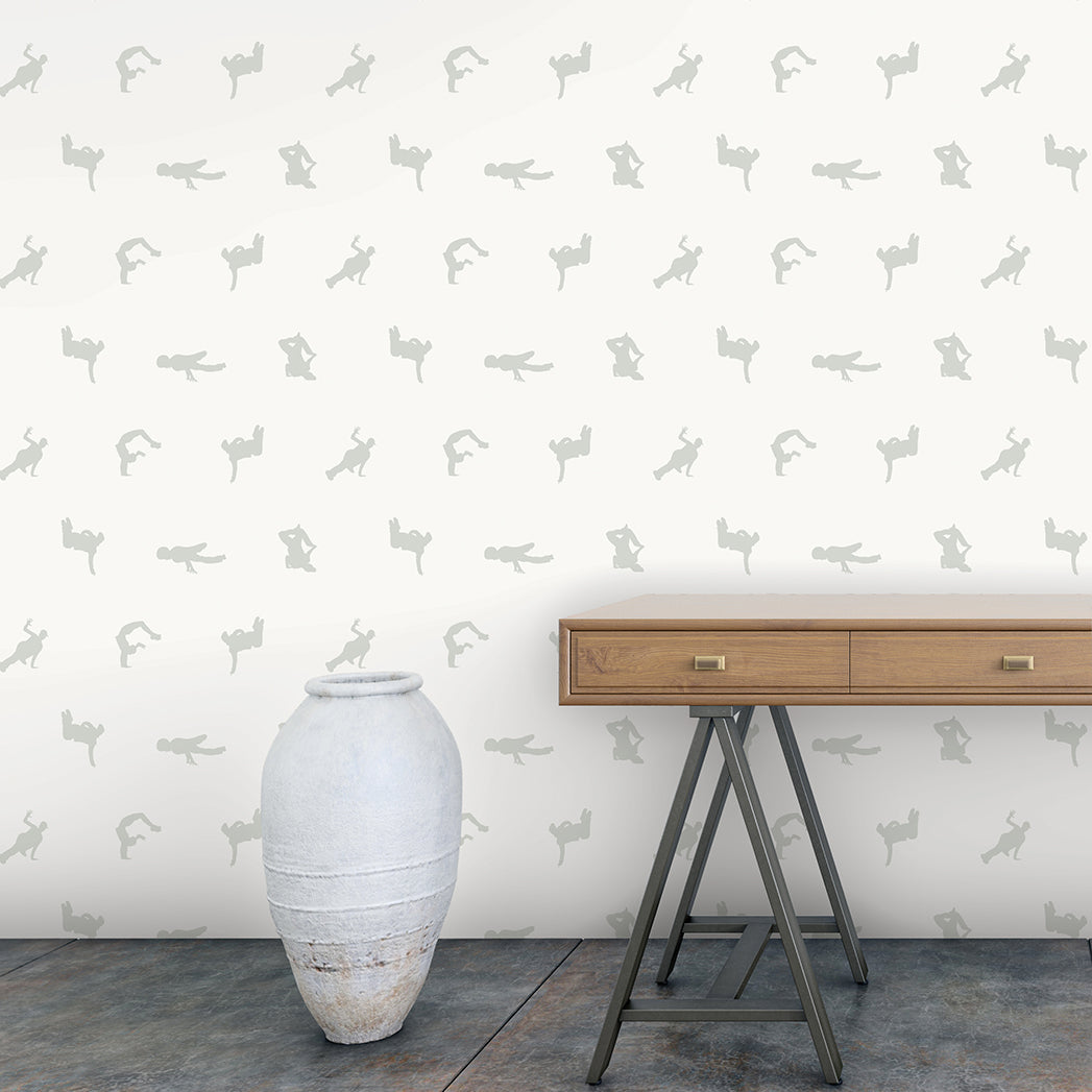 Breakers peel and stick wallpaper in a white and grey colorway displayed in an entryway behind a wooden bench and floor vase.