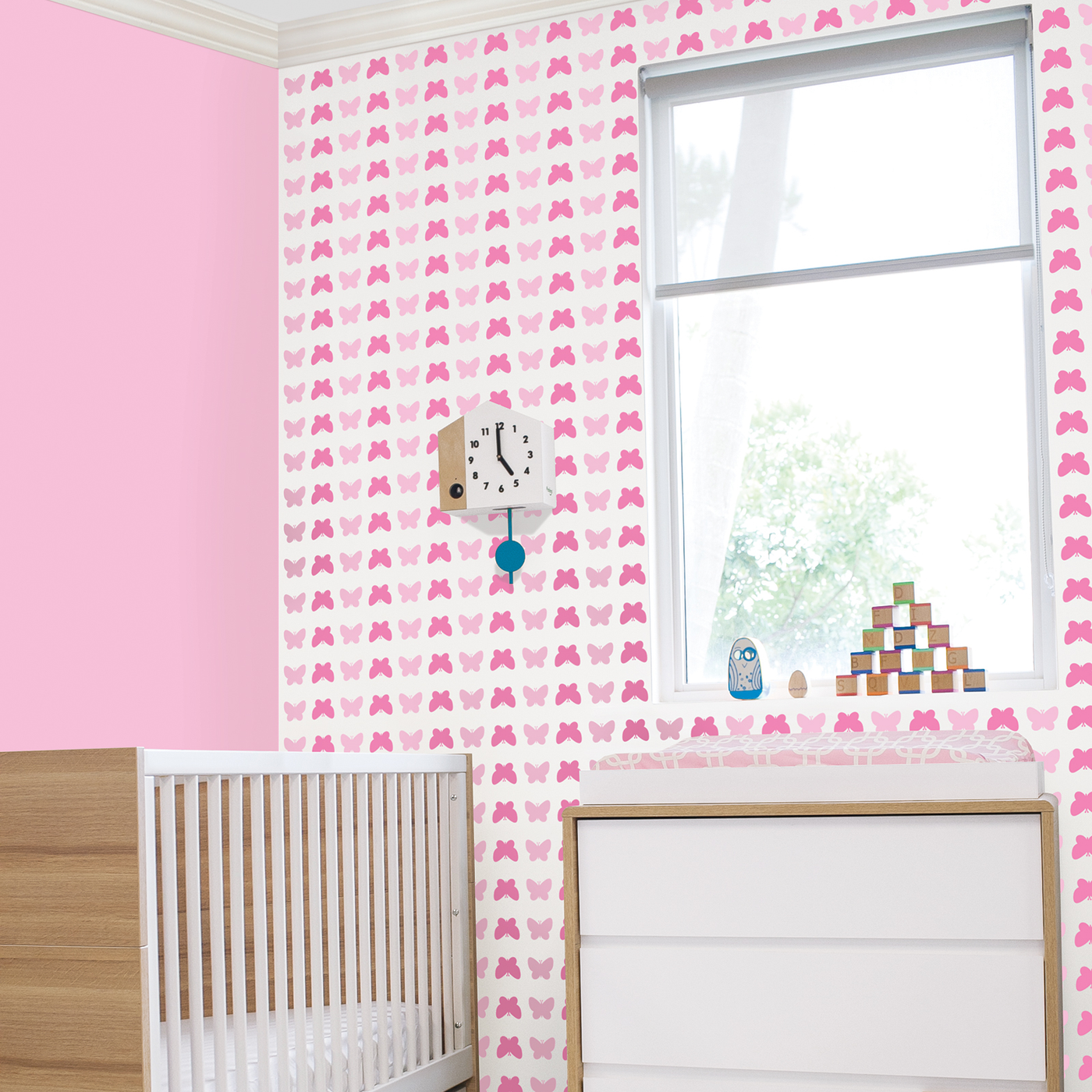 Butterfly peel and stick wallpaper in pink in a kids bedroom.
