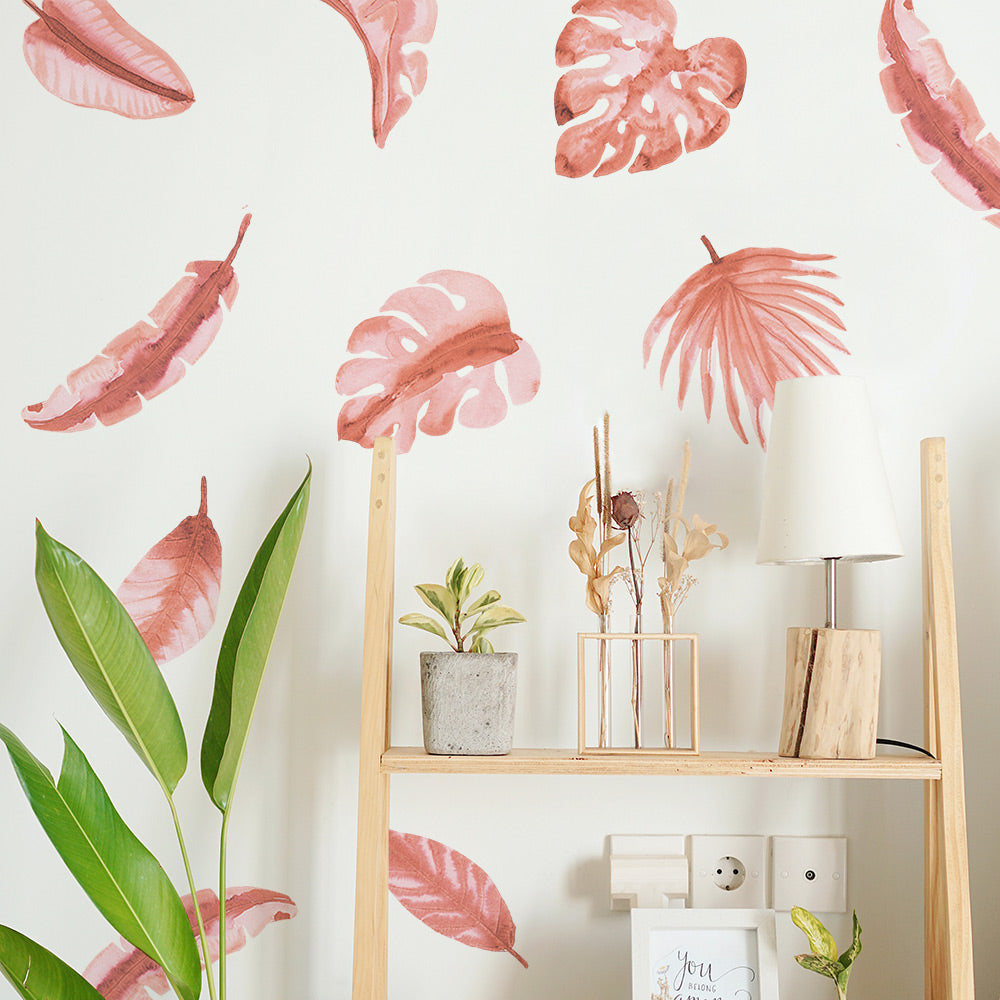Tempaper's Watercolor Palm Leaf Wall Decals behind a wood bookshelf and a plant.
