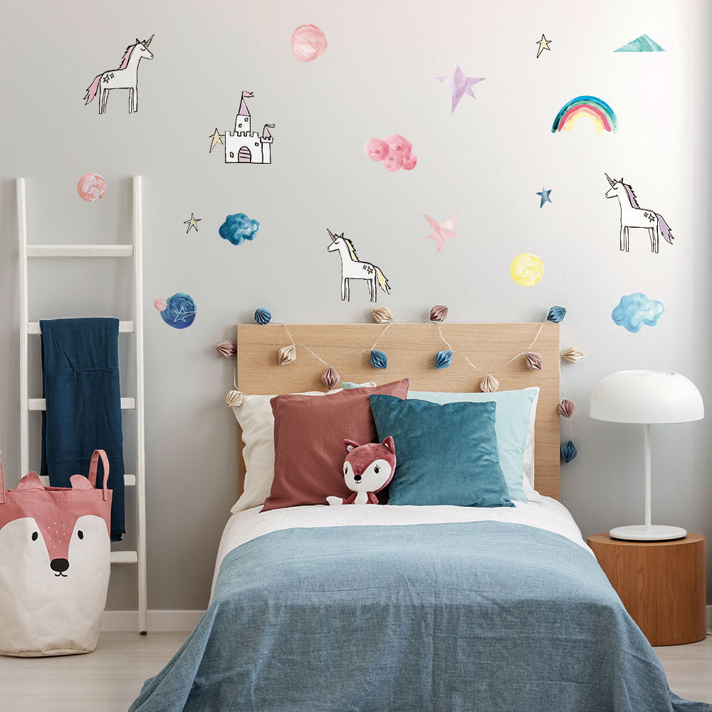 Tempaper's Rainbows & Unicorns Removable Wall Decals in a kids bedroom above a bed.