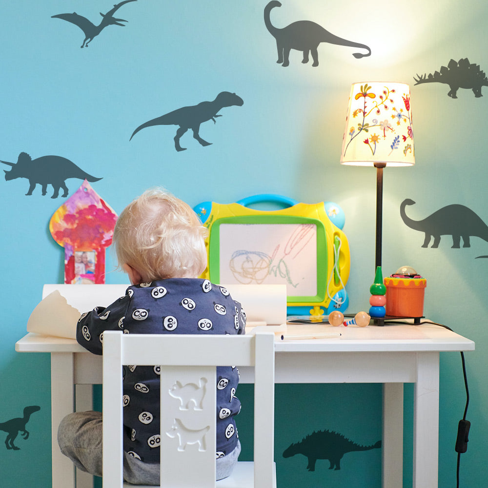 Tempaper's Dinosaur Wall Decals shown with a kid playing at a desk.