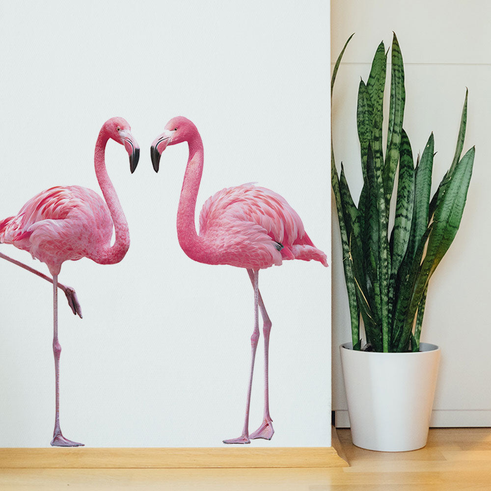 Tempaper's Flamingos Wall Decals shown on a wall with a plant.
