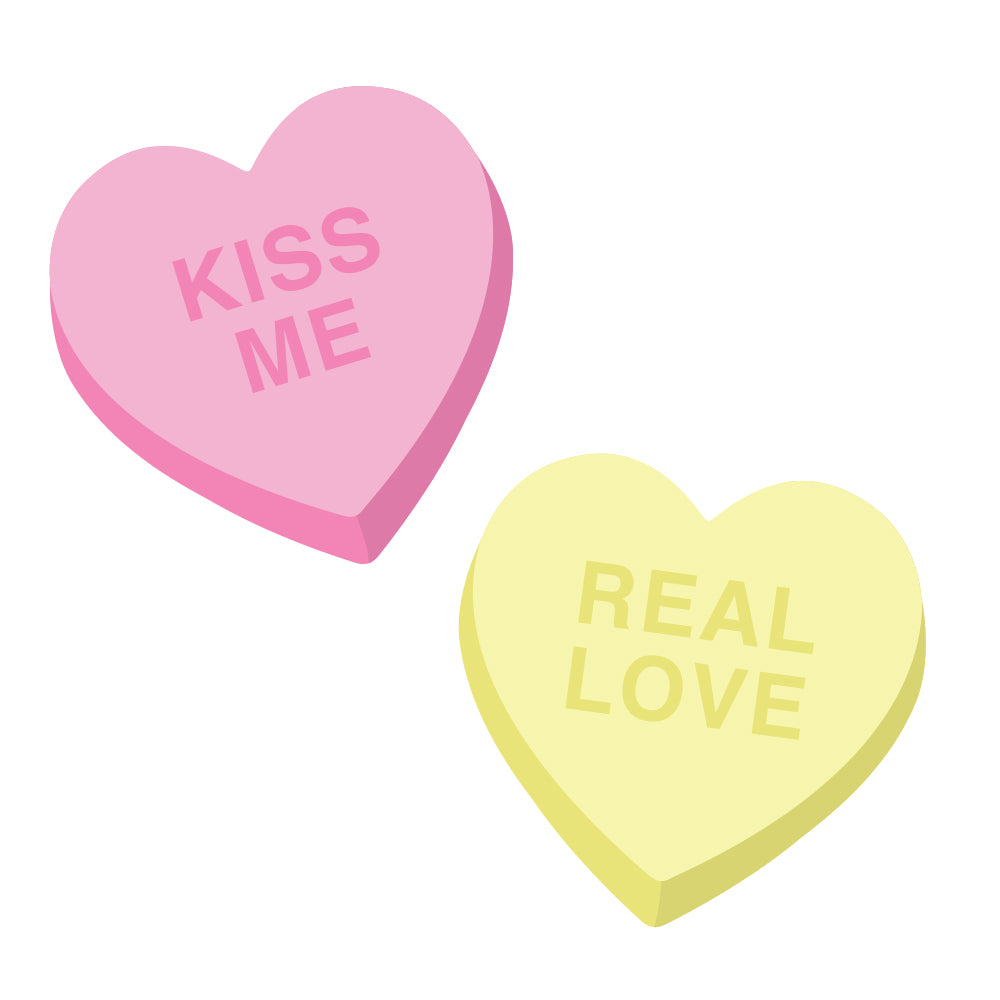 Two candy hearts, one yellow with the words "Real Love" and one pink with the words "Kiss Me," that are part of the Candy Heart wall decals from Tempaper.