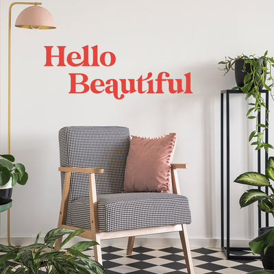A room filled with plants and a black and white chair showing the bold look of the Hello Beautiful wall decal from Tempaper.