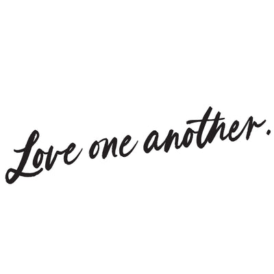 The words "love one another" written in black cursive from the Love One Another wall decal set from Tempaper.