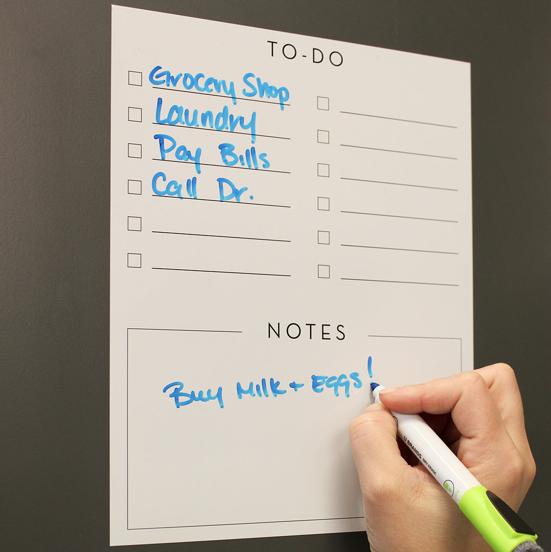 A person writing on Tempaper's Dry Erase To-Do List Wall Decal.