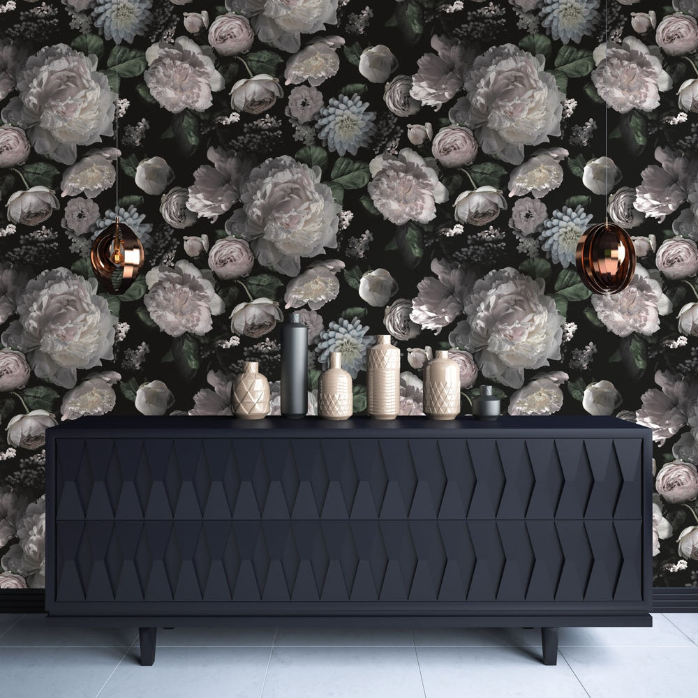 A long black cabinet with jars staggered across the top and Moody floral peel-and-stick wallpaper from Tempaper on the wall behind.