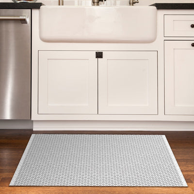 Tempaper's Diamond Geometric Vinyl Rug shown in a kitchen in front of a sink.