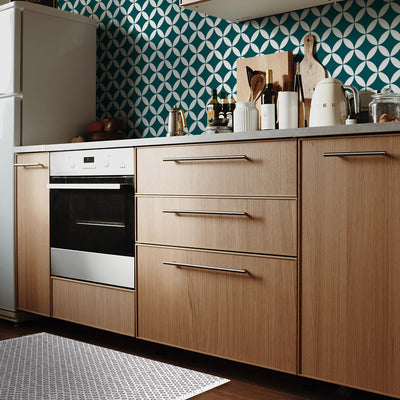 Tempaper's Diamond Geometric Vinyl Rug shown in a kitchen in front of an oven.