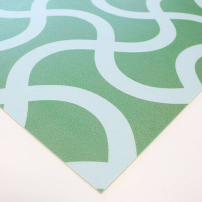 A corner of Tempaper's Flourish Vinyl Rug in blue and green.#color_trippy-teal