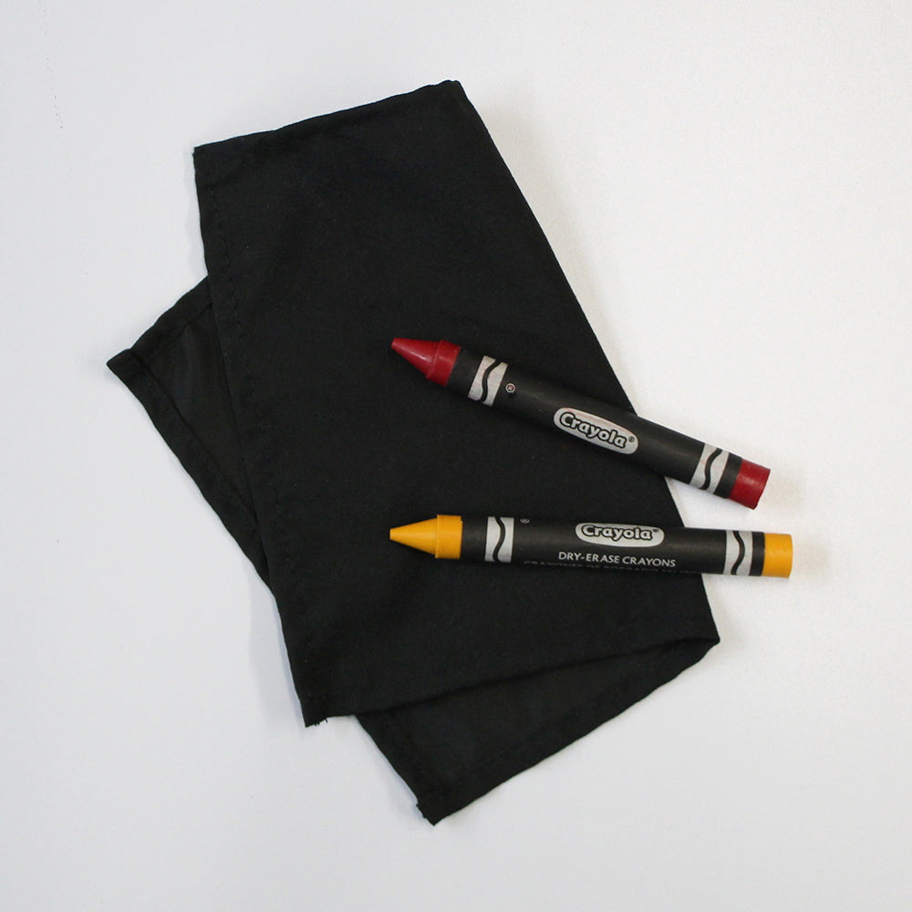 A red and yellow Crayola Dry Erase Crayon on a cloth.
