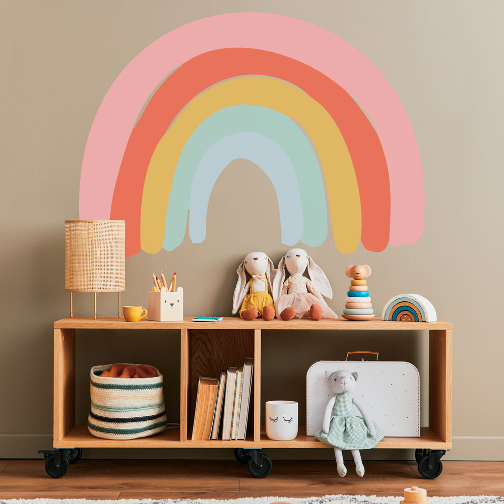 Tempaper's Pastel Rainbow Wall Peel And Stick Decal behind a sideboard in a kids bedroom.